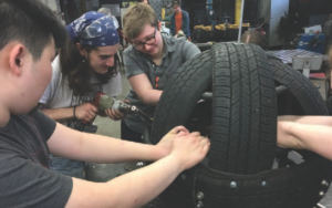 young people making a structure out of tires. 